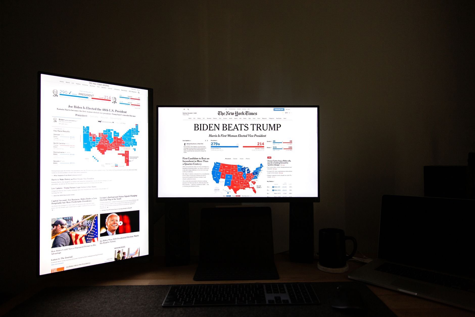 Dual monitors displaying election results in a dark strategic command center